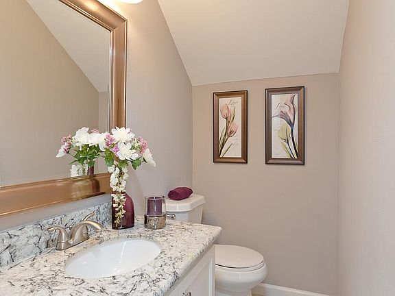 Halt bath at bottom of stairs complete with tile, granite, cabinets, and framed mirror!