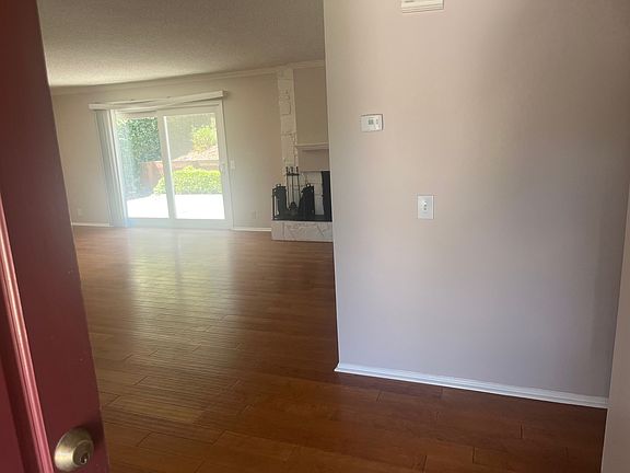 View from front door into the living room. Hall with beds/baths to the right, kitchen, living, dining to the left.