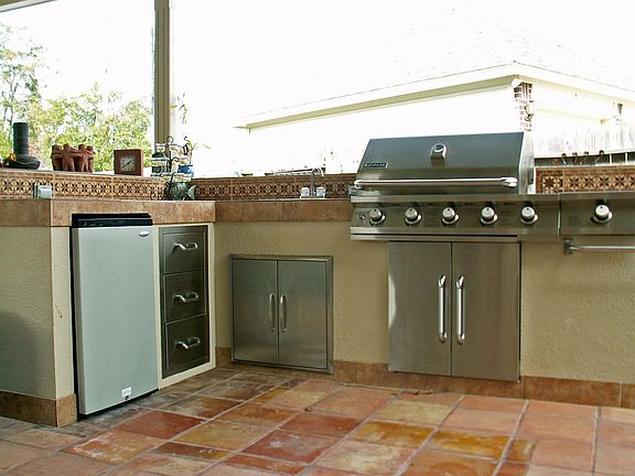 Kitchen features stainless Jen-Air grill and burner, sink, refrigerator, storage, drawers