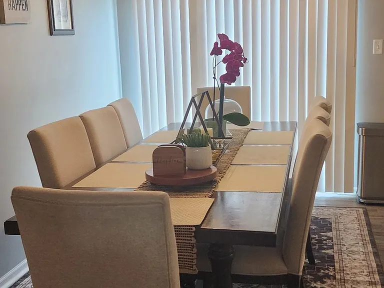 Dedicated dining area with a full-size table for six, pendant lighting, and sliding-door access to outdoor light.