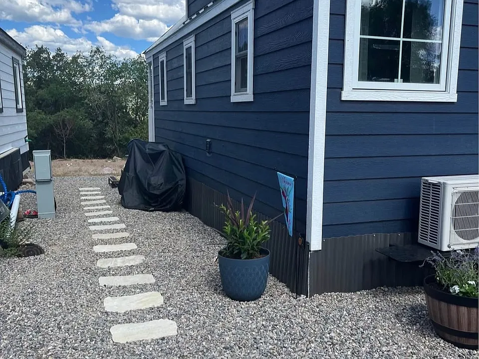 Two parking spots and stone walkway to main door.