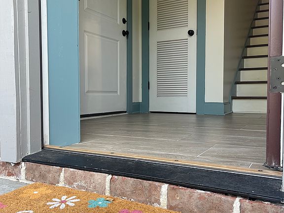 Entryway with coat closet, entrance to 2-car garage (on left) and staircase to main level.