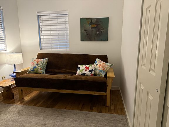 Second bedroom or office area. Table and lamp for computer, futon couch bed, wool rug, and additional seating.