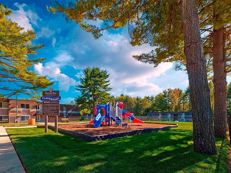 Family-friendly playground at Haynes Run Apartments, offering outdoor fun and shaded green space in Medford, NJ.