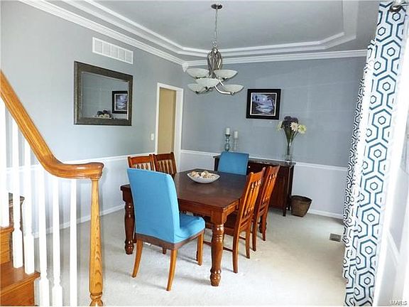 Dining room with 2 large windows, chair rail and tray ceiling.