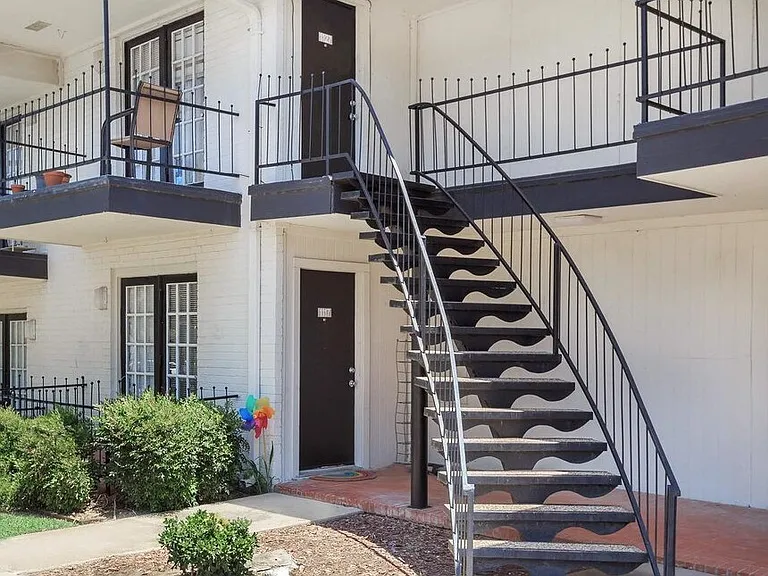 Charming exterior design featuring private patios and balconies surrounded by beautiful landscaping.