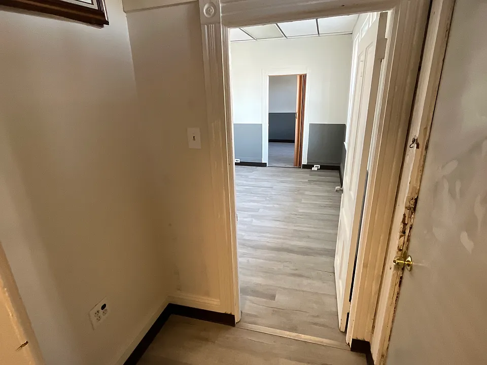 Small hallway space leading forward with side door entrance to the back unit (right door).