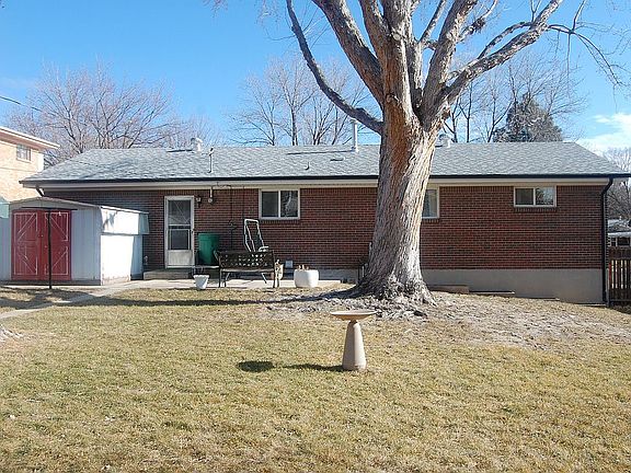 Large fenced backyard with patio and storage shed.