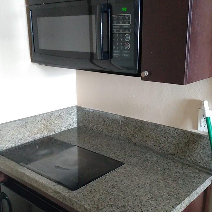Electric stove, small refrigerator and microwave.