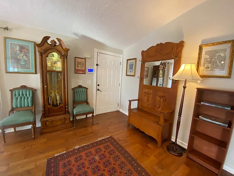 Entry to House Featuring Grandfather Clock and Antique Bench with Coat Hooks