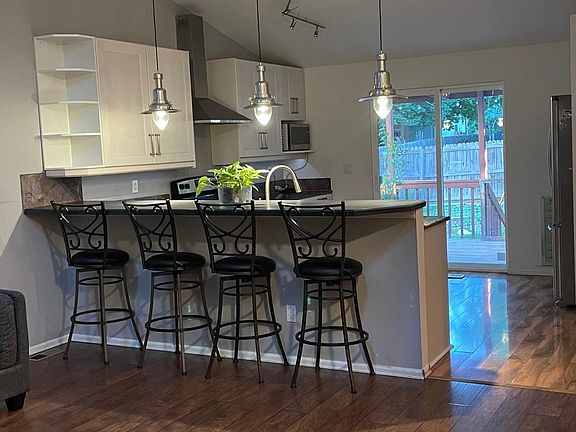 Living room with kitchen counter that seats 4, opens to the kitchen and patio