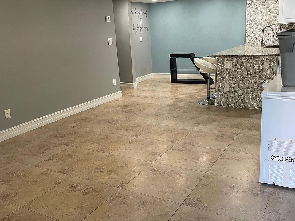 Open floor plan. Brand new paint, tile throughout, modern lighting. View of living room and dining area, with kitchen counter top.