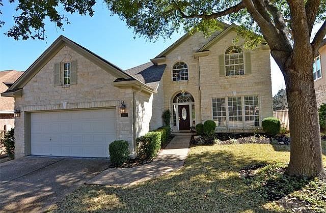 Austin Stone and a large oak add to the curb appeal of this home