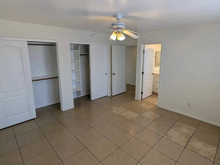 This spacious primary bedroom features an attached full bath and the added luxury of two separate closets for ample storage and organization.