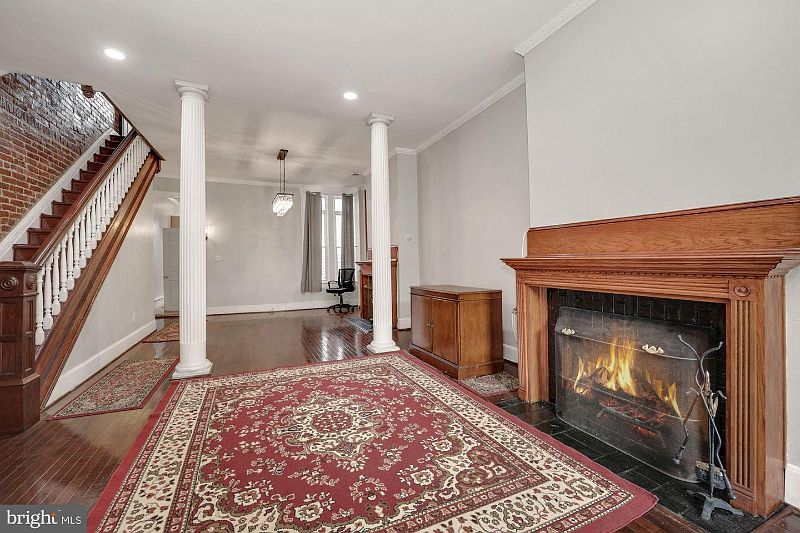 Ballroom Living room with 2nd FP in 2 column, lovely hardwood floors & exposed brick staircase