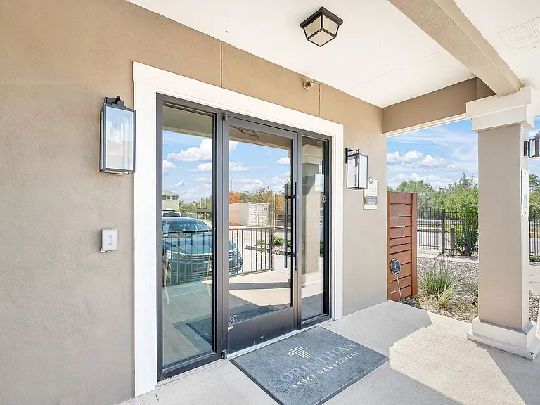 Entrance of La Joya Apartments in Laredo, Texas, featuring a door and a car parked in front