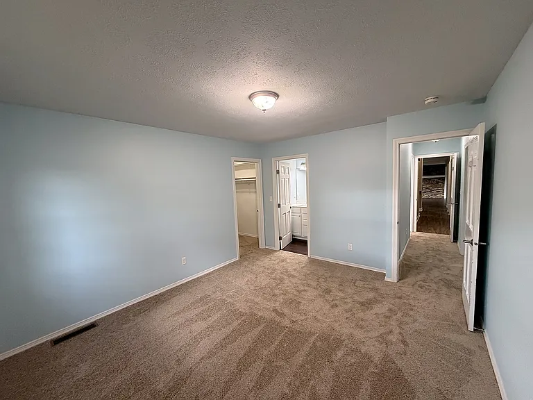Primary Bedroom with view of walk-in closet and ensuite bathroom