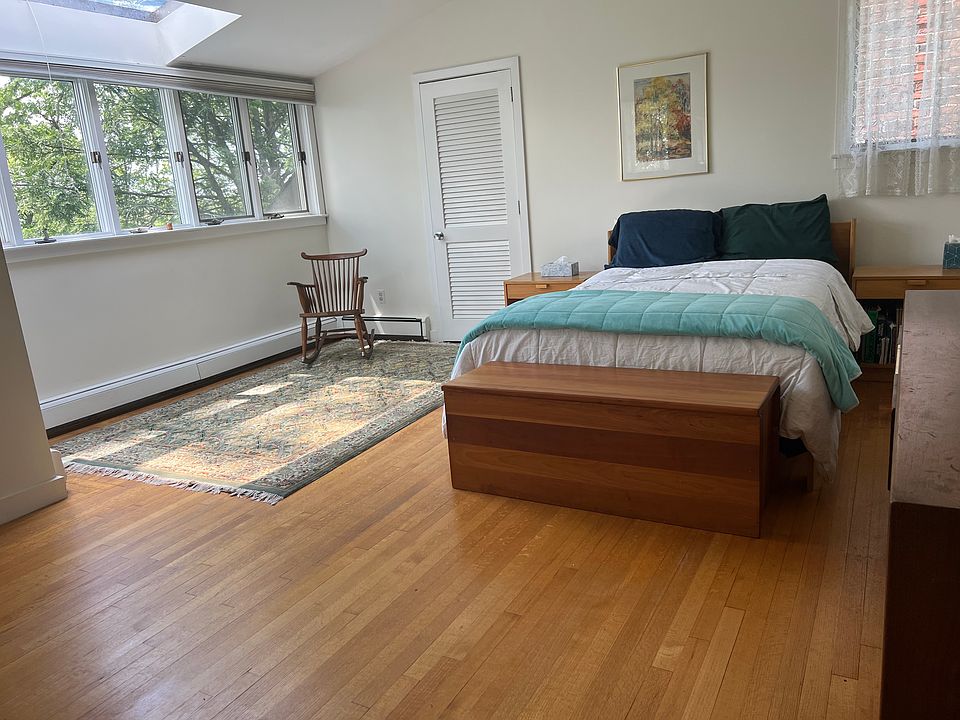 Bright, spacious primary bedroom with hardwood floors, loft ceiling, skylight and ensuite bathroom