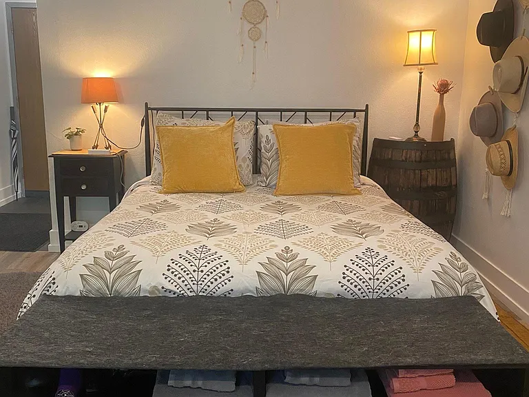 Storage at the foot of the bed for shoes, humidifier, hair dryer, and towels.