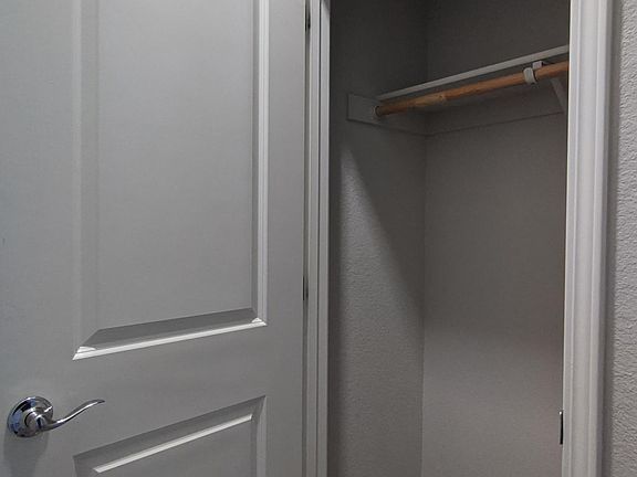 Coat closet before the half bath near entryway.