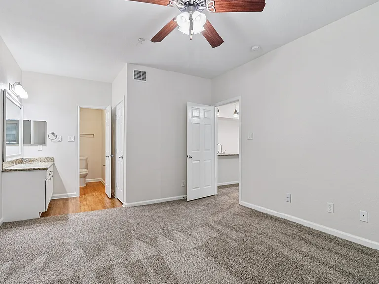 Bright and airy bedroom with plush carpet, contemporary ceiling fan, and access to en-suite bathroom. Bright and airy bedroom with plush carpet, contemporary ceiling fan, and access to en-suite bathroom.