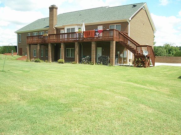 back of home, large deck and patio on 2.24 acres