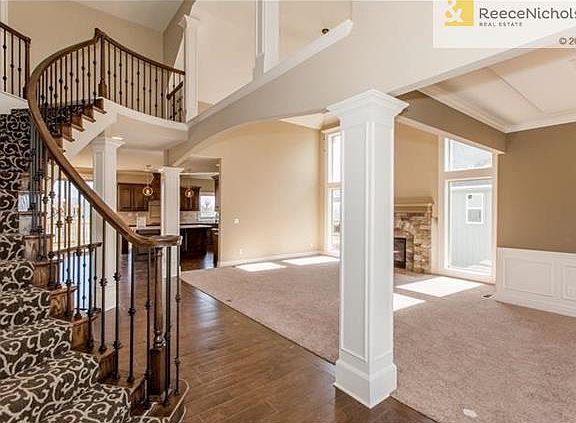 GRAND CIRCULAR STAIRCASE AT ENTRY - WOOD FLOOR PATH TO KITCHEN - GREAT ROOM ON RIGHT