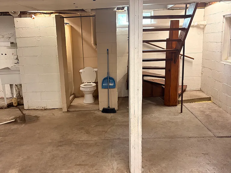 basement with half bath and stairs to house