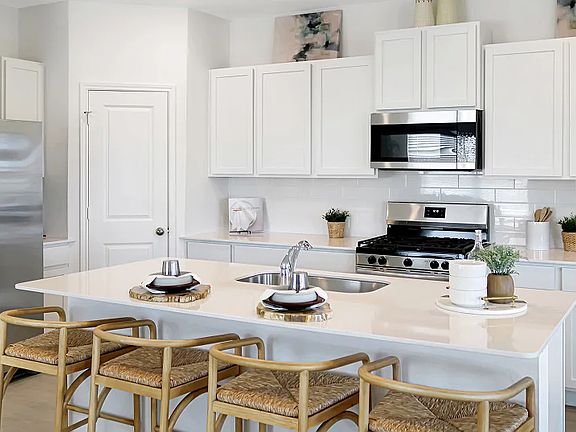 With brand-new stainless steel appliances, ample cabinetry storage and a corner pantry, this kitchen is functional and stylish (Staged model home photo)