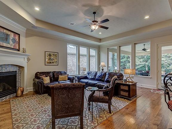 Large inviting living area with picture windows looking out over the covered patio and wooded backyard. Tray ceiling with can lighting, and cozy fireplace. Don't miss the amazing security system in this home with surround sound.