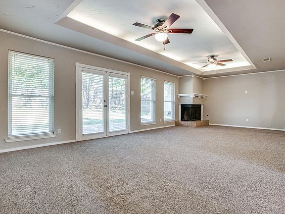 Large living room with corner fireplace, and double doors to