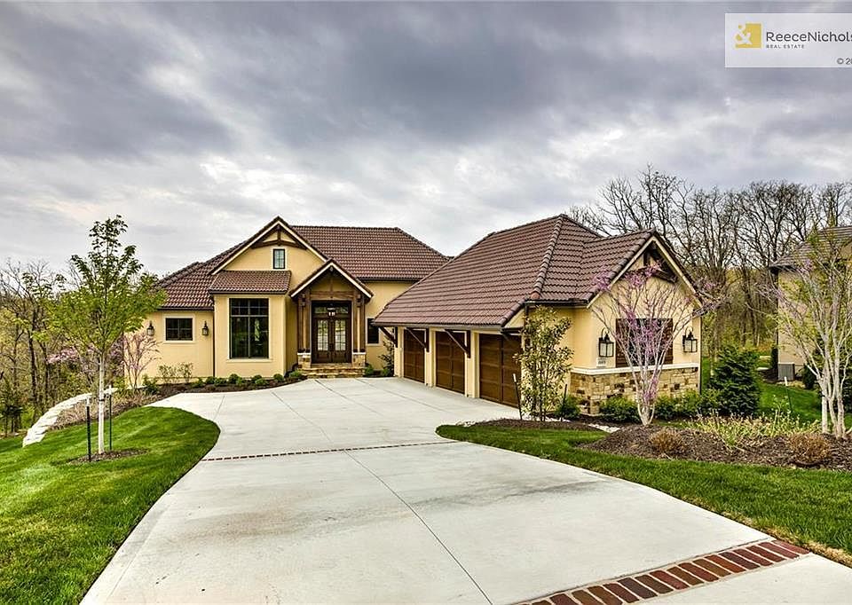 Beautiful stucco and stone home with tile roof set far back from the street.