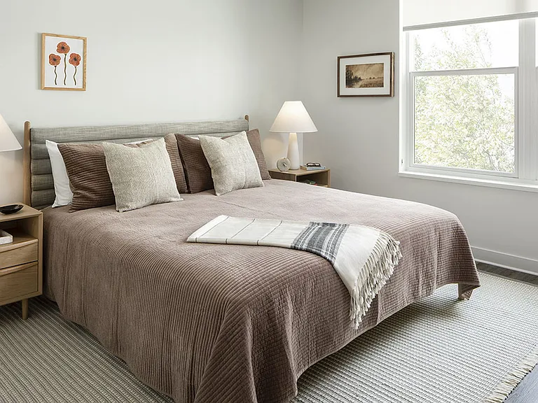 Spacious apartment bedroom with wood floors.