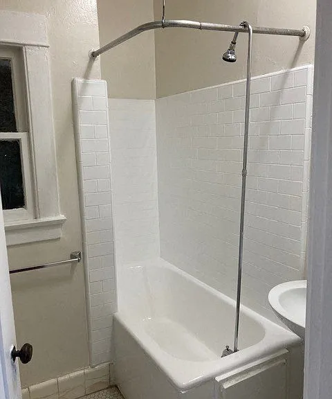 Bathroom with white tile and fixtures at The Western at Rosewood in Los Angeles, California.