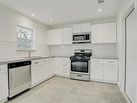 Wow! What a lovely modern kitchen. The white subway tiles look fresh and clean. The light grey quartz counters are found in the 