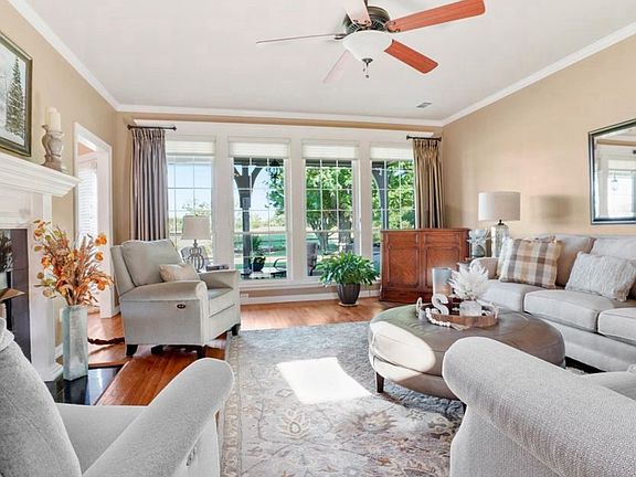 down stairs living room with view of backyard, mature trees and golf course