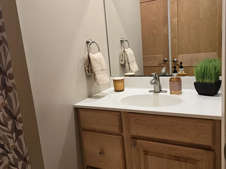 Bathroom with Maple cabinets and large mirror.