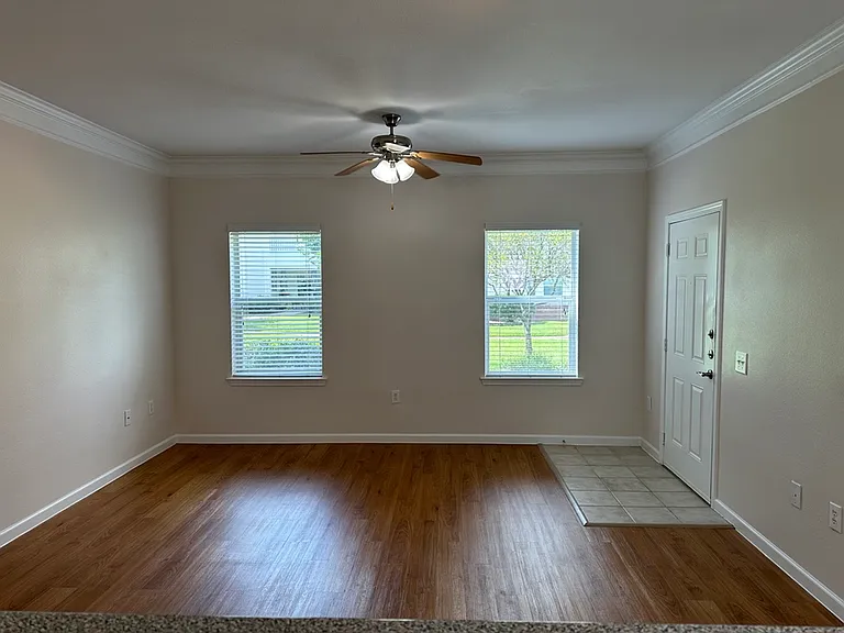 Inviting living room with natural light, warm wood-style floors, and a cozy ceiling fan. Inviting living room with natural light, warm wood-style floors, and a cozy ceiling fan.