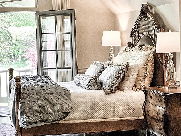 Upper-level master bedroom suite w/ day bed + balcony overlooking the grounds, elegant sitting room, attached nursery, and sprawling walk-in closet.