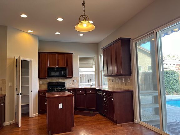 Well laid out kitchen with pantry and view of the pool