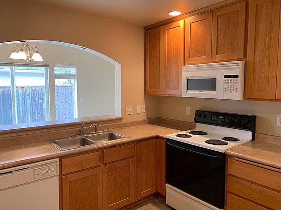 Kitchen looking into dining area. Backyard patio out slider door.