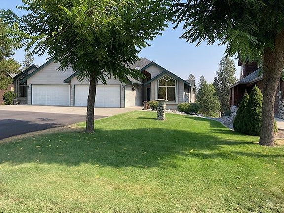 spacious green space paved drive way rock landscape