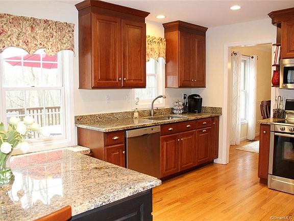 Stainless steel appliances and custom cabinetry. There is a built-in spice rack next to the stove.