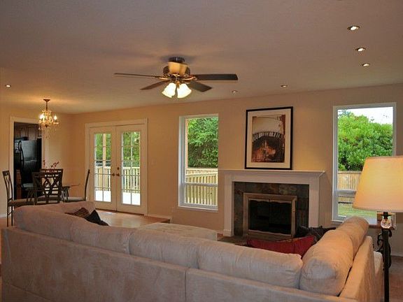 As you enter, you are greeted by plenty of natural light from west facing view and cozy fireplace. Dining area to left in the photo is one of two eating areas. The other eating area is in kitchen and family area to left of the photo.