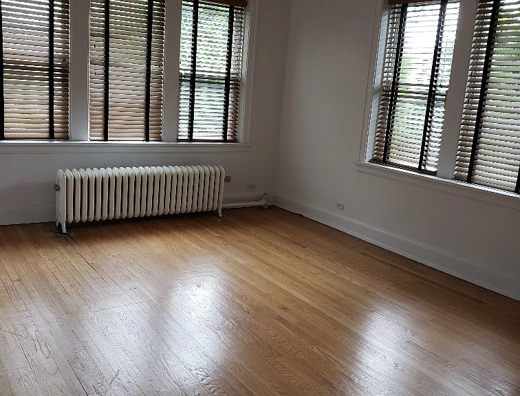Freshly painted view of main bedroom w/wood floors and designer wood window shades