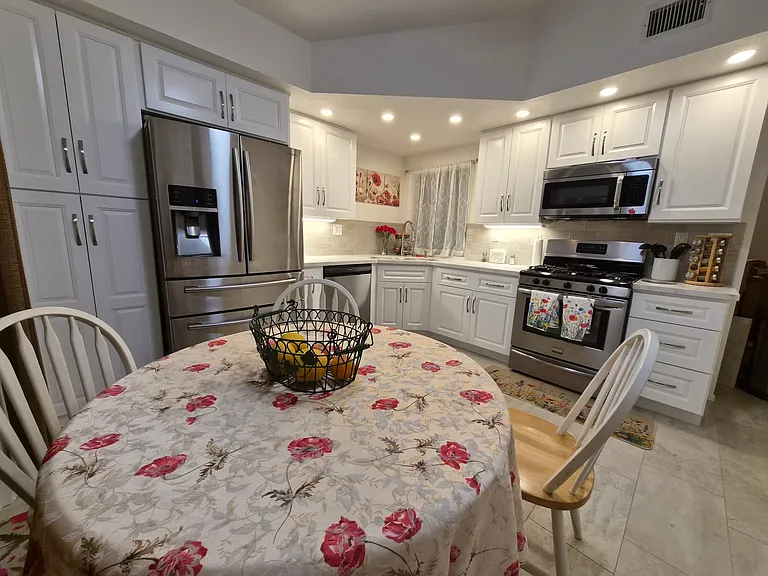 modern kitchen with stainless steel appliances. Fully equipped kitchen, cookware, dishes, glasses, mugs, utensils