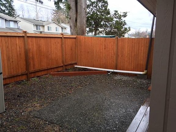 Large backyard space with newer fence and storage unit, ceme