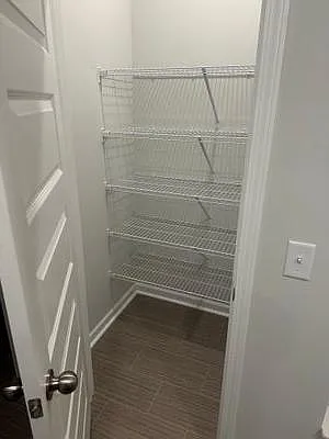 Dedicated storage closet with multiple wire shelves, offering convenient organization for pantry items or household supplies.