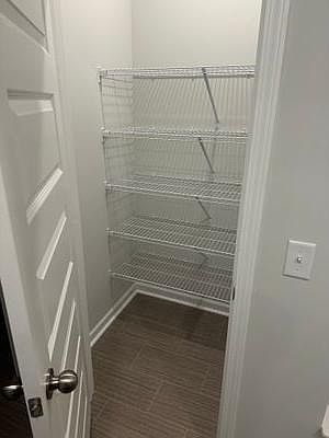 Dedicated storage closet with multiple wire shelves, offering convenient organization for pantry items or household supplies.