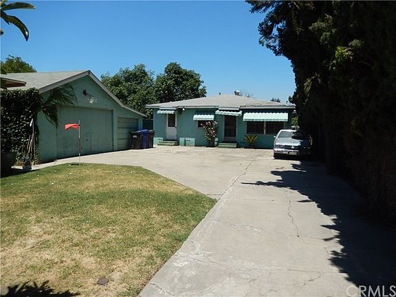 Full view of back house from driveway, and 3 car garage and 4th parking space (open)